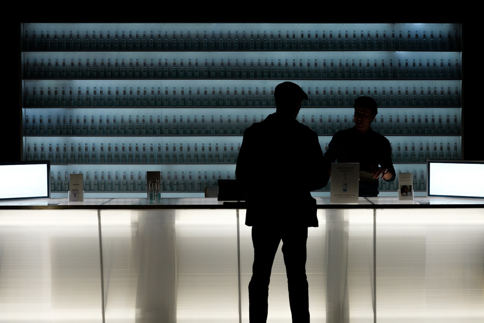 silhouette of man standing near glass counter top