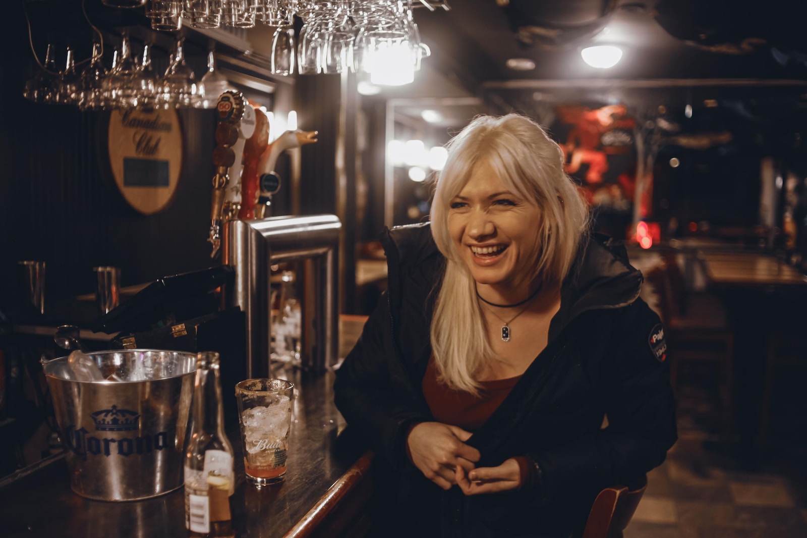 a woman sitting at a bar with a smile on her face
